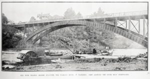 Freetrader passing Mercer, note floating logs in foreground. Photo:sir-george-grey-special-collections-auckland-libraries-awns-19200909-37-3 